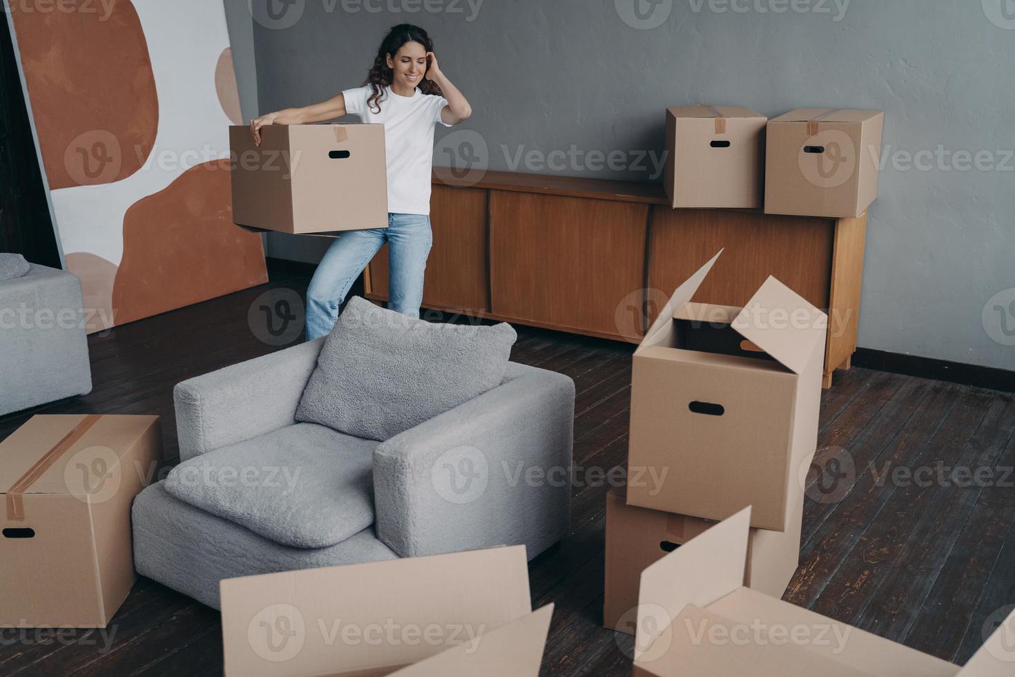 glimlachen vrouw Holding karton doos in beweging naar nieuw huis. hypotheek reclame, verhuizing concept foto