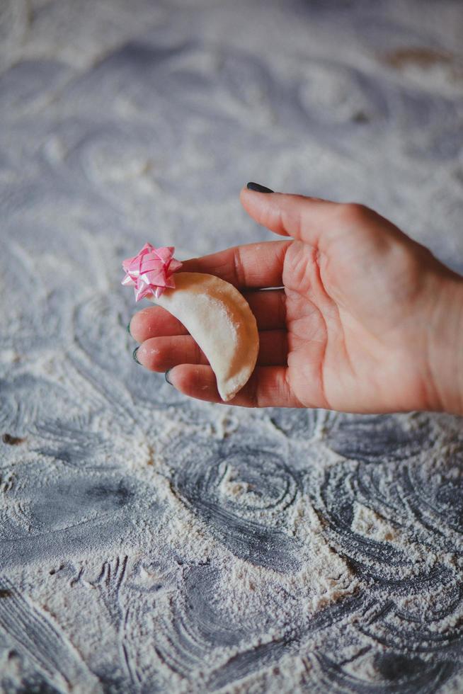 close-up van de hand met empanada met roze strik erop foto