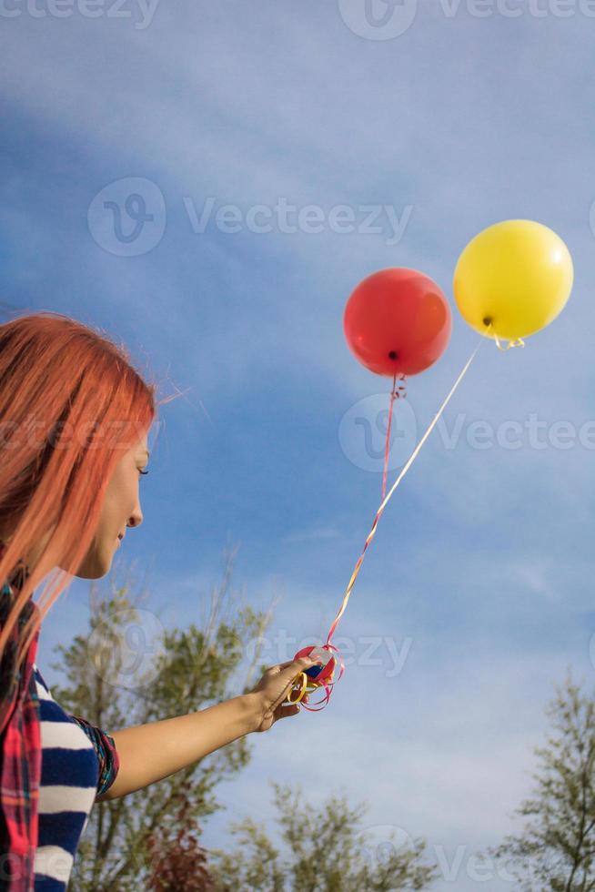 hieronder visie van vrouw met kleurrijk ballonnen tegen de lucht. foto