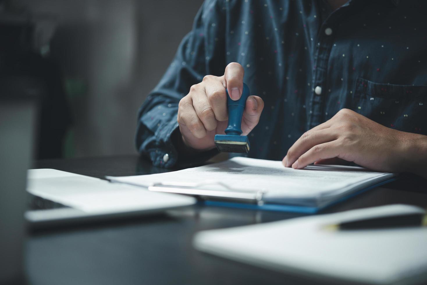 ondertekening goedkeuring Vermelding documenten postzegel bevestiging bezetting handtekening. zakenman hand- stempelen financiën papier werk concept. foto