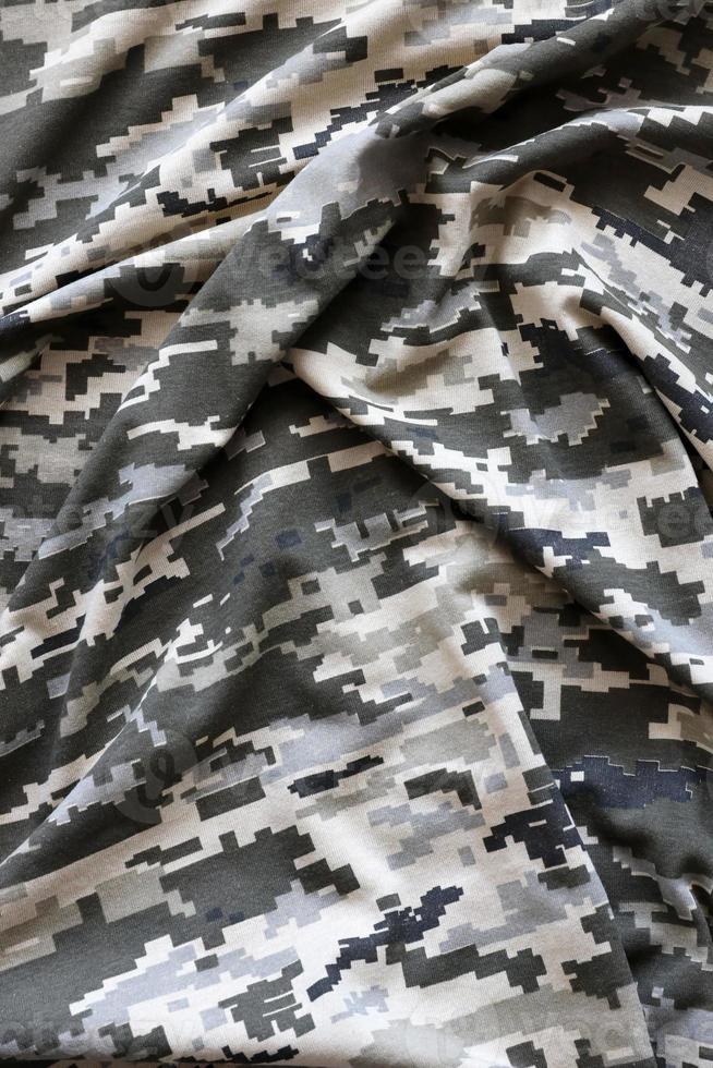 kleding stof met structuur van oekraïens leger korrelig camouflage. kleding met camo patroon in grijs, bruin en groen pixel vormen. officieel uniform van oekraïens soldaten foto