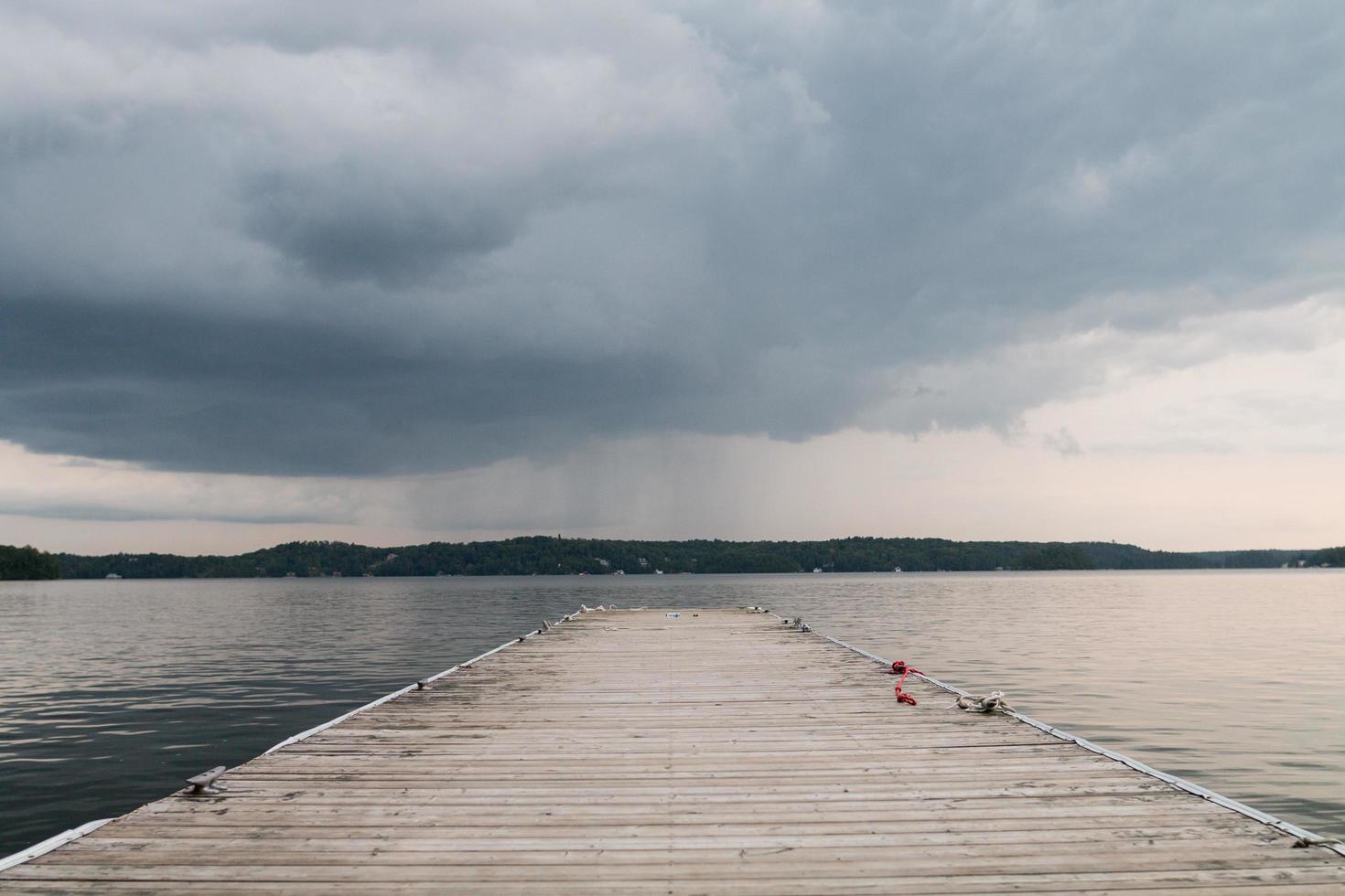 houten dok op watermassa onder bewolkte hemel foto