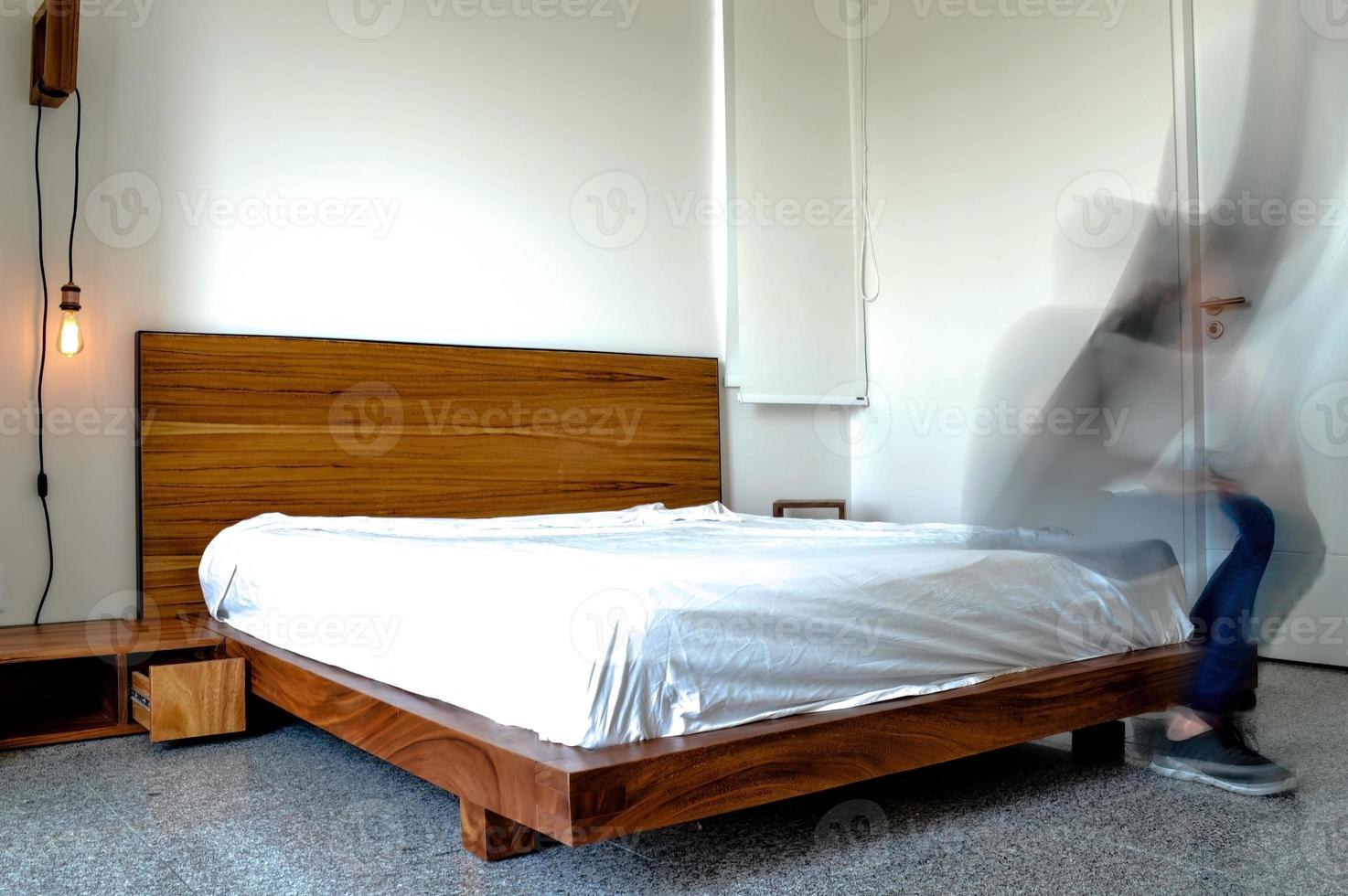 bed baseren, slaapkamer met mat Aan de vloer, klei pot in de achtergrond, houten dressoir en spiegel. foto