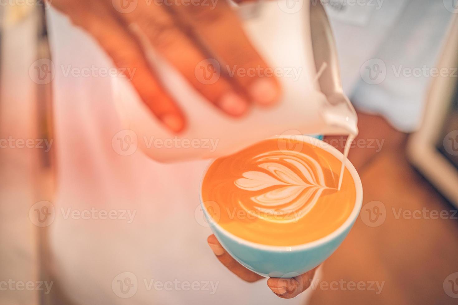 barista maken een kop van koffie latte kunst. detailopname visie van kop van ochtend- drank. idyllisch gelukkig positief stemming, ontbijt foto