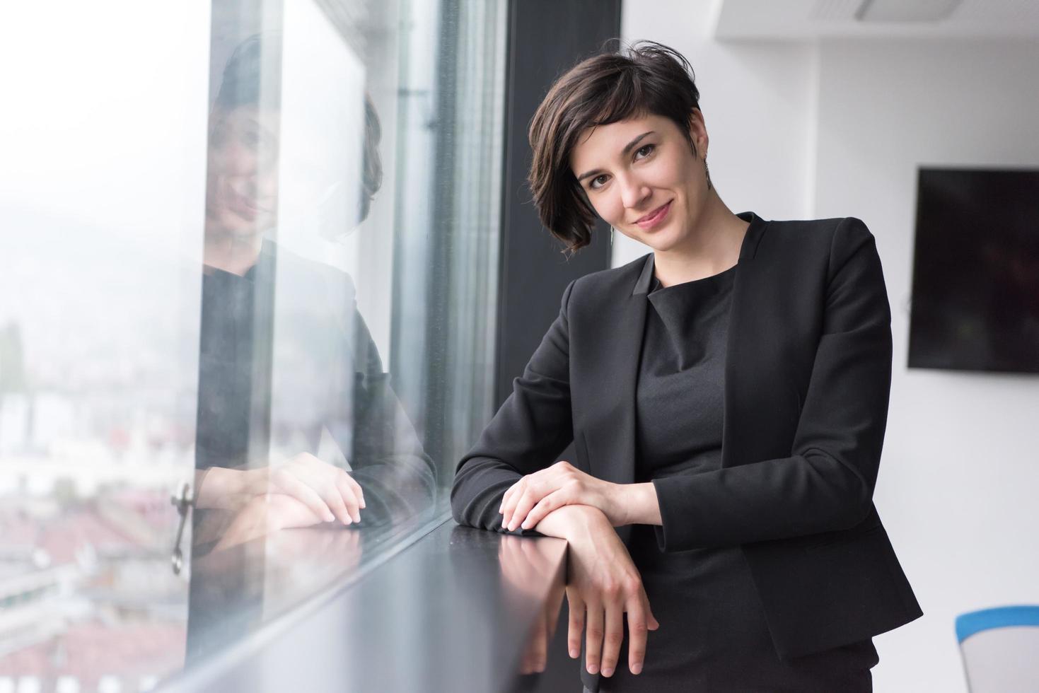 portret van geslaagd zakenvrouw door de venster foto