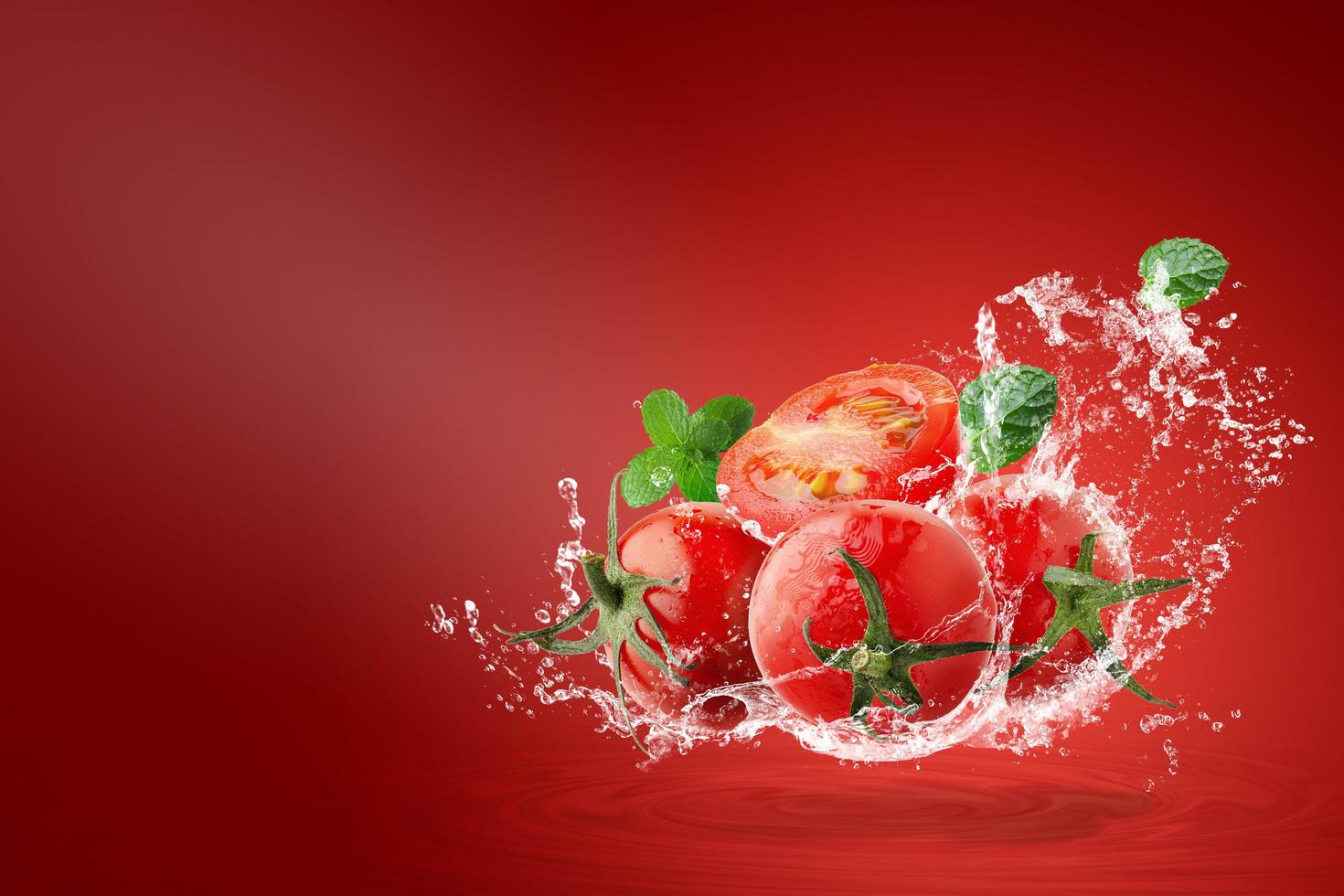 water spatten op verse rode tomaten foto