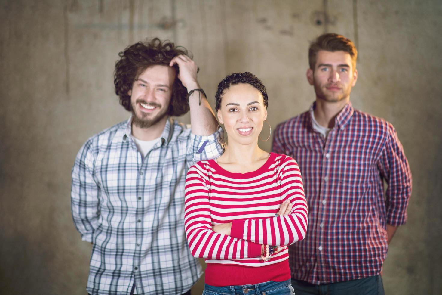 portret van gewoontjes bedrijf team in voorkant van een beton muur foto