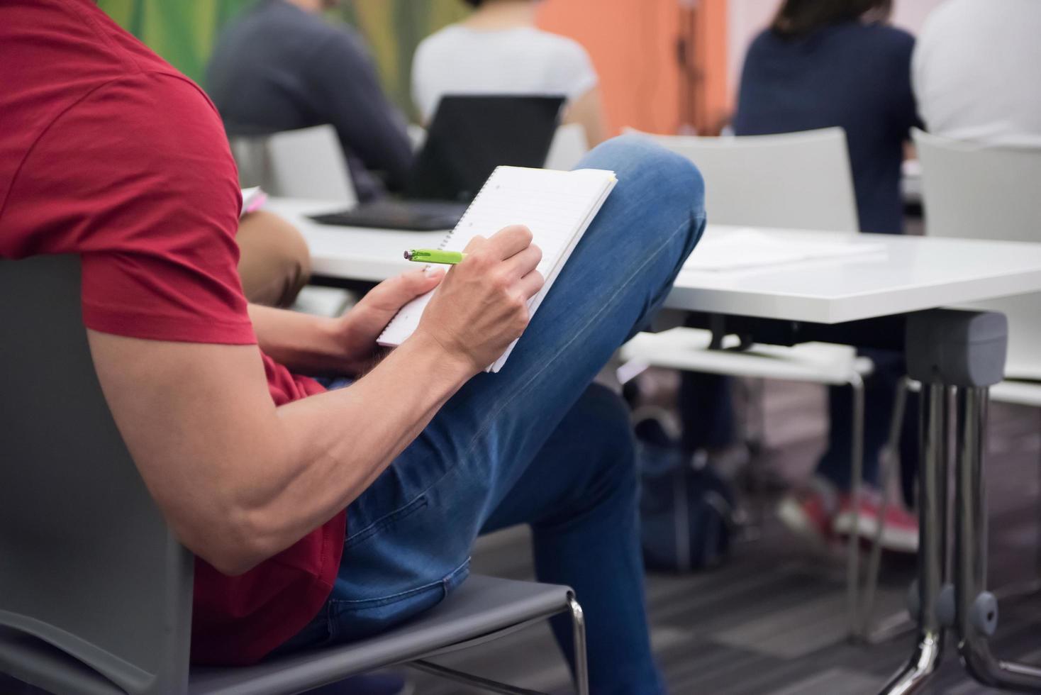 mannetje leerling nemen aantekeningen in klas foto