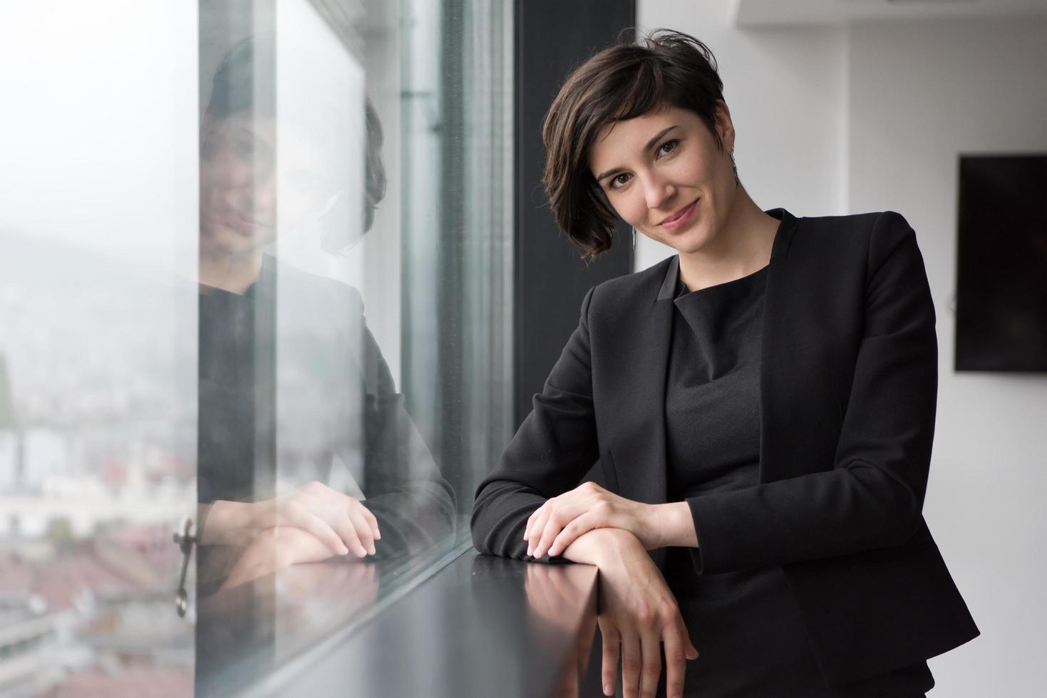 portret van geslaagd zakenvrouw door de venster foto