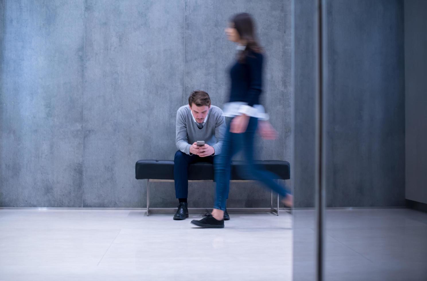 zakenman gebruik makend van mobiel telefoon terwijl zittend Aan de bank foto