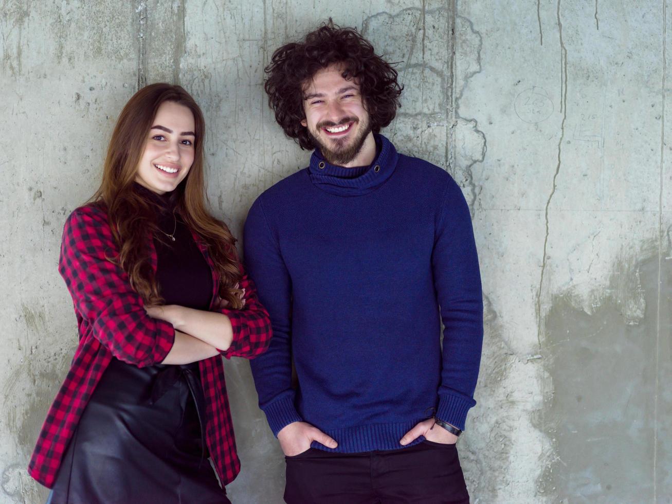 portret van gewoontjes bedrijf paar in voorkant van een beton muur foto