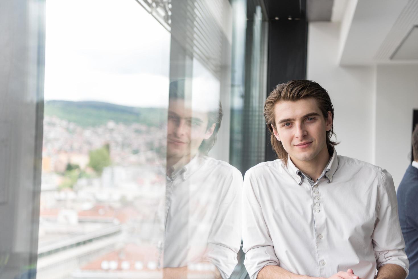 jong zakenman in opstarten kantoor door de venster foto