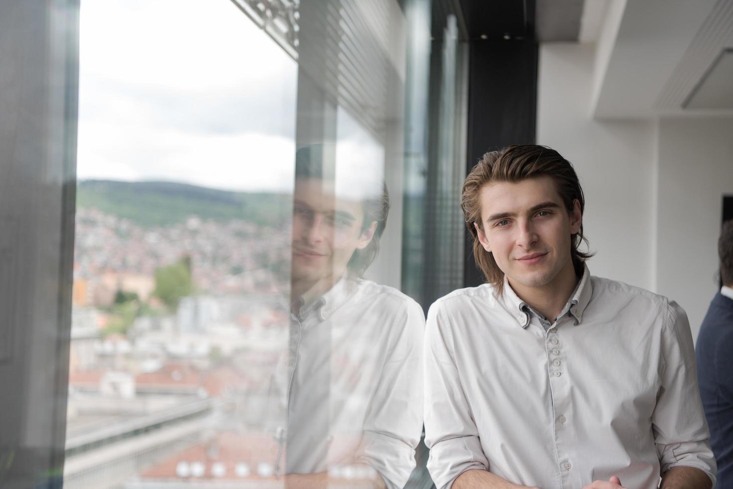 jong zakenman in opstarten kantoor door de venster foto