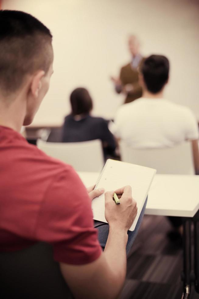 mannetje leerling nemen aantekeningen in klas foto