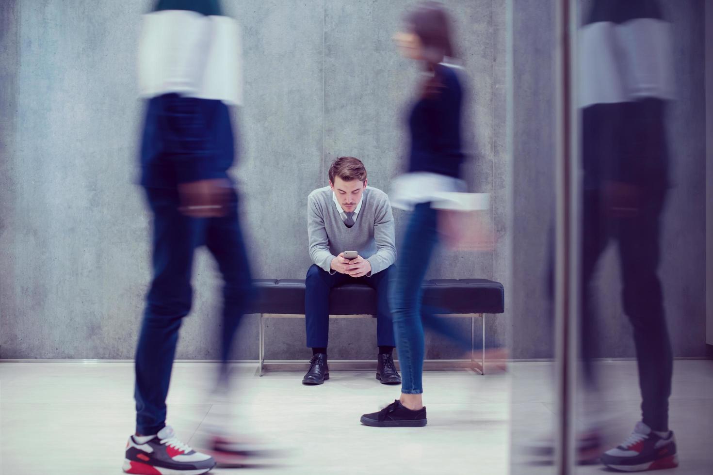 zakenman gebruik makend van mobiel telefoon terwijl zittend Aan de bank foto