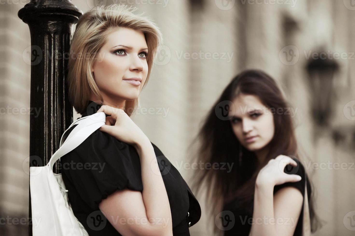 twee gelukkige jonge vrouwen op de stadsstraat foto