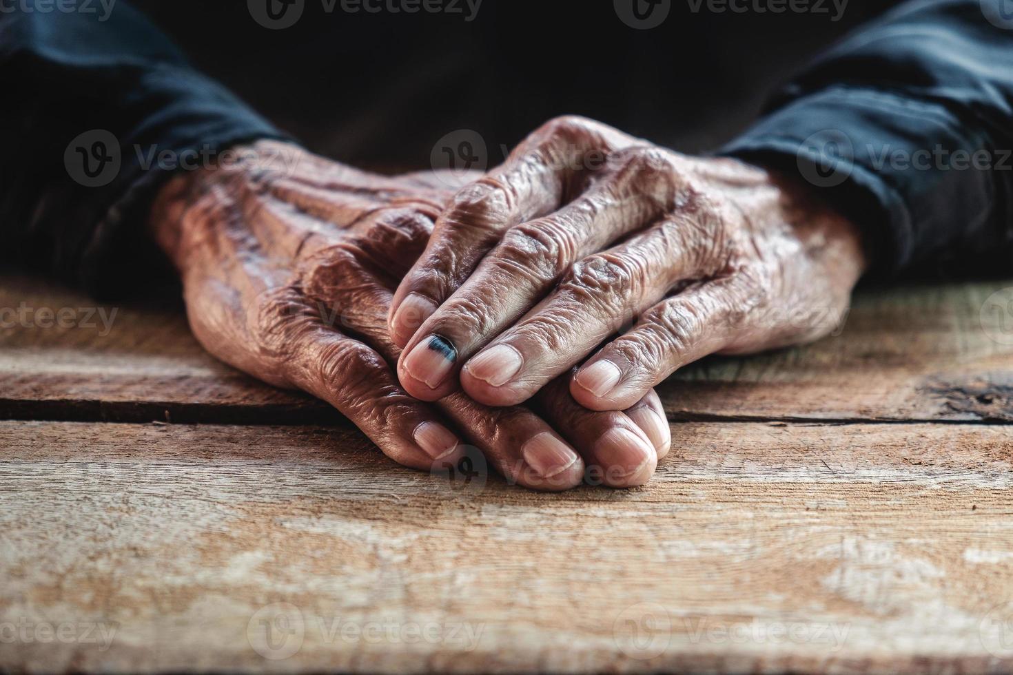 close-up van mannelijke gerimpelde handen, oude man draagt foto