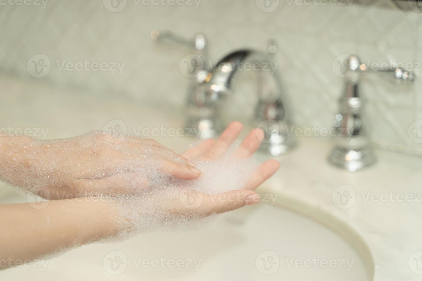 vrouw hand- gebruik zeep en het wassen onder de water tik. hygiëne concept. foto