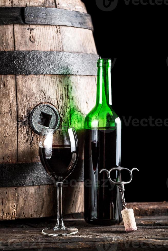 glas wijn en fles in de oude kelder foto