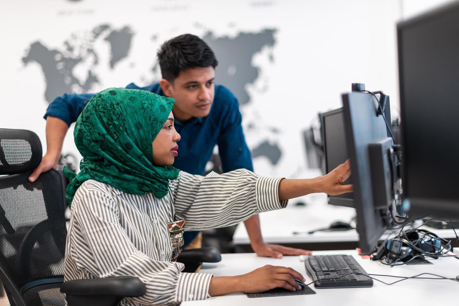 multi-etnisch opstarten bedrijf team Arabisch vrouw vervelend een hijab Aan vergadering in modern Open plan kantoor interieur brainstormen, werken Aan laptop en bureaublad computer. selectief focus foto