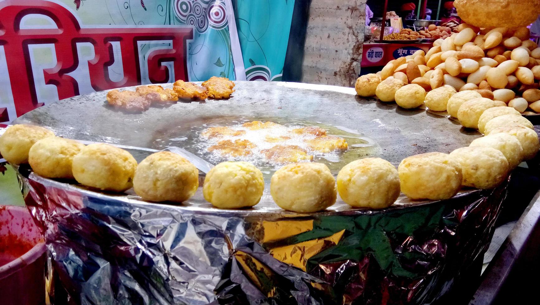 Mens maken aloo tikki, gebakken aardappel koteletten, voedsel kraam Indië straat voedsel. foto