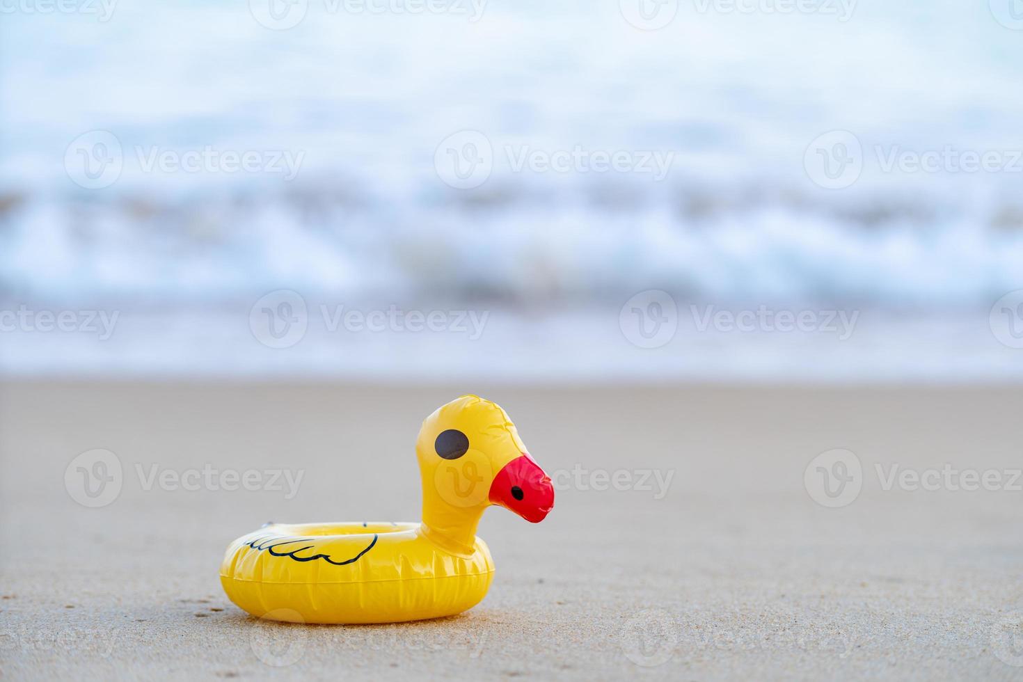 geel rubber eend Aan de kust in de ochtend, zand strand. foto