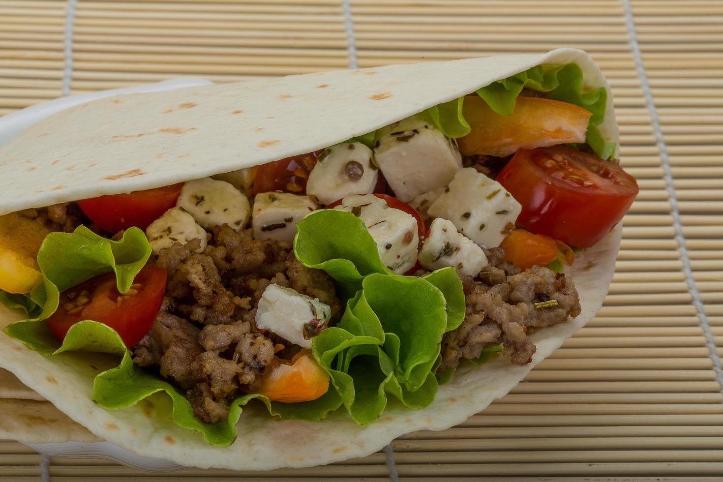 varkensvlees tortilla Aan de bord en houten achtergrond foto