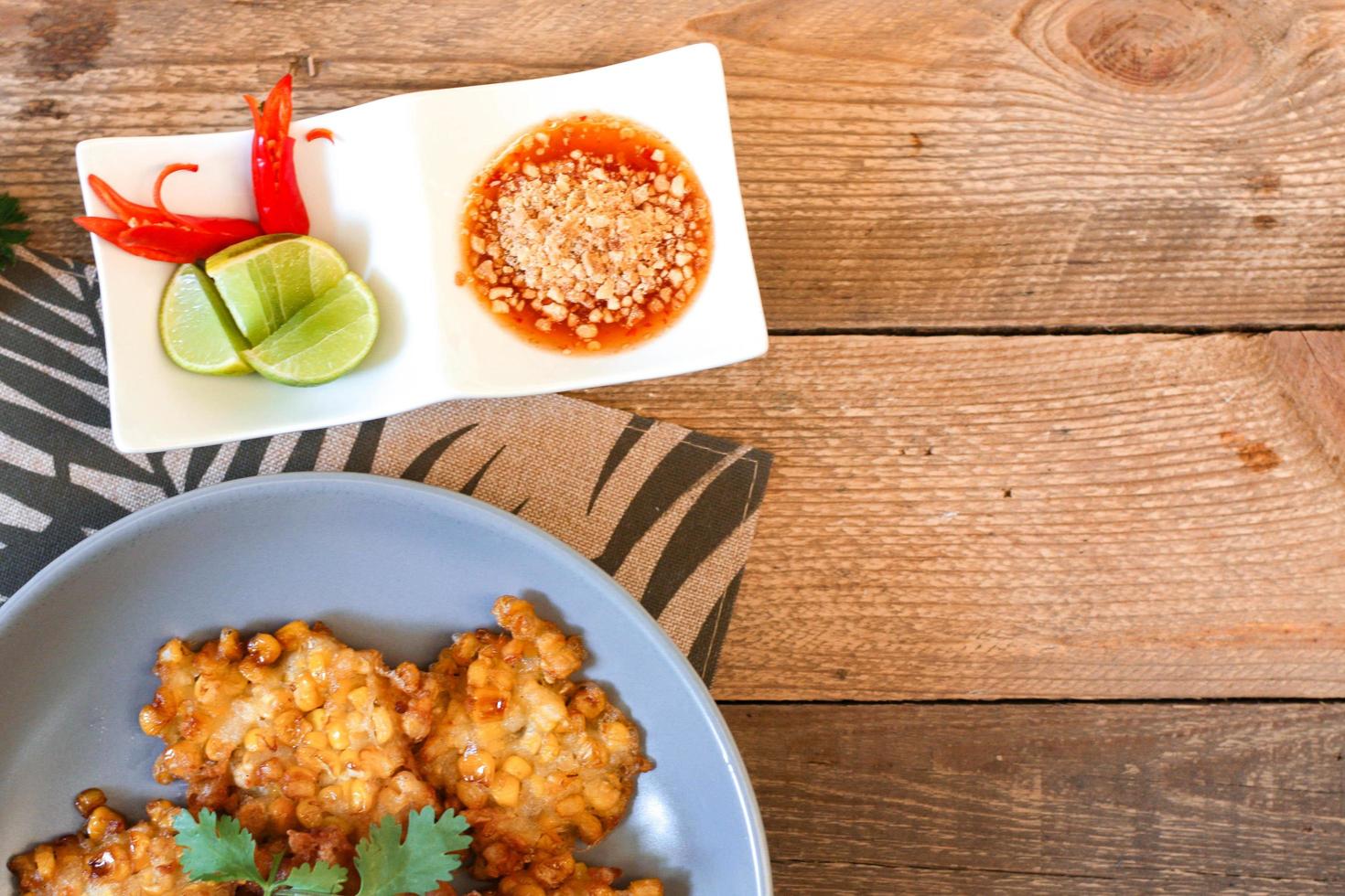 maïs beignets met Chili saus geplaatst Aan een houten tafel foto