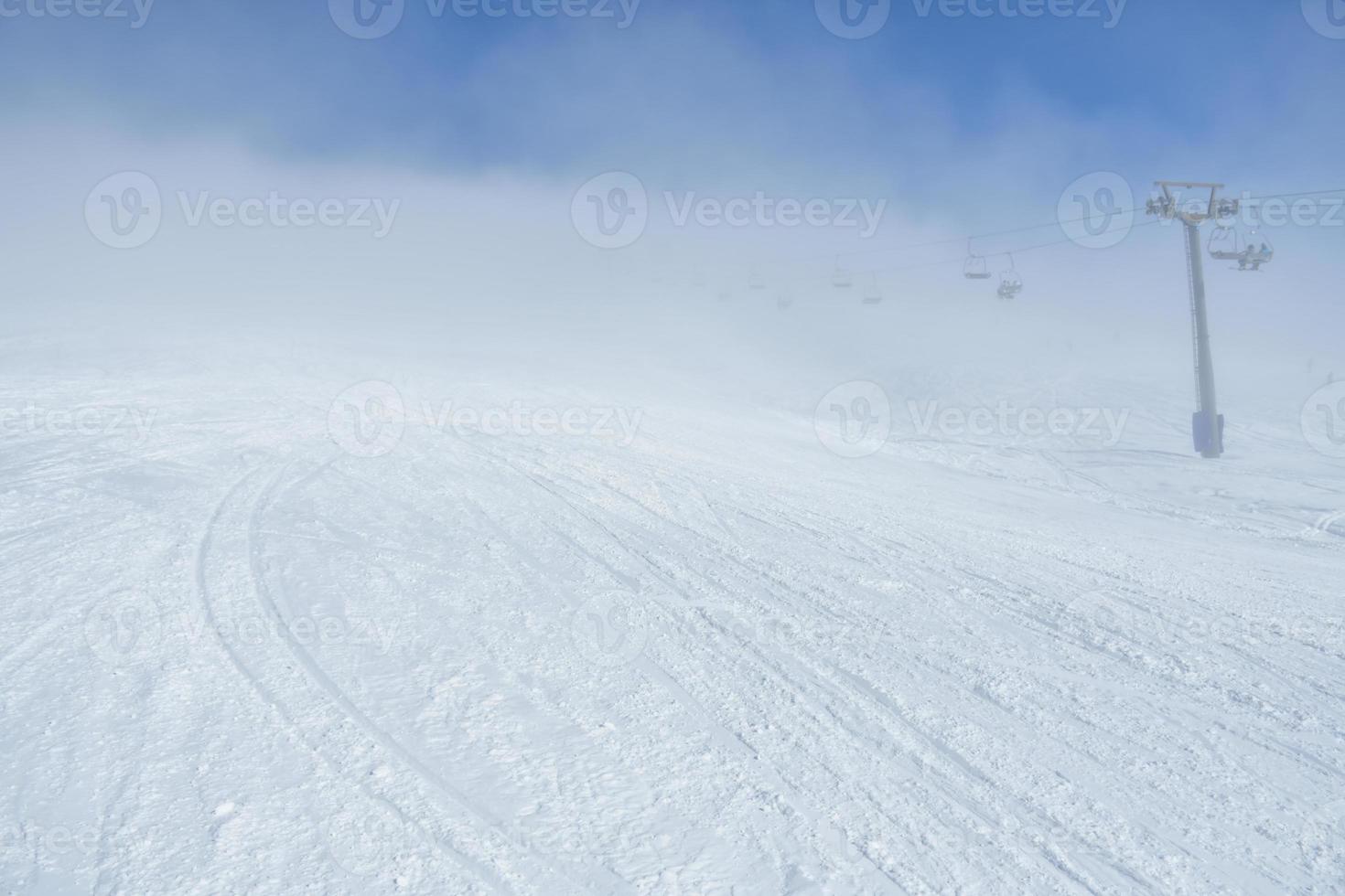 ski toevlucht helling met beperkt zichtbaarheid met niemand in de ochtend. slecht en veranderlijk weer voorwaarden foto