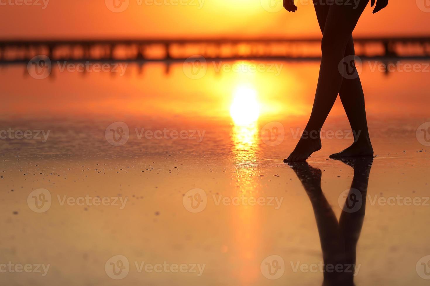 zijaanzicht beelden van mooie jonge vrouw in het zwembroek wandelen op het strand naar de zee. meisje is erg slank foto