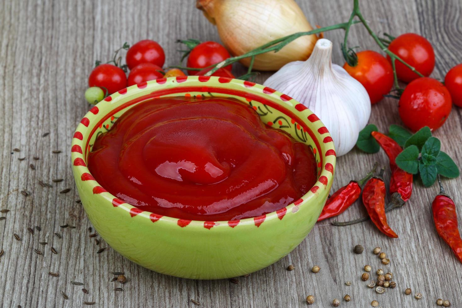 tomaat ketchup in een kom Aan houten achtergrond foto