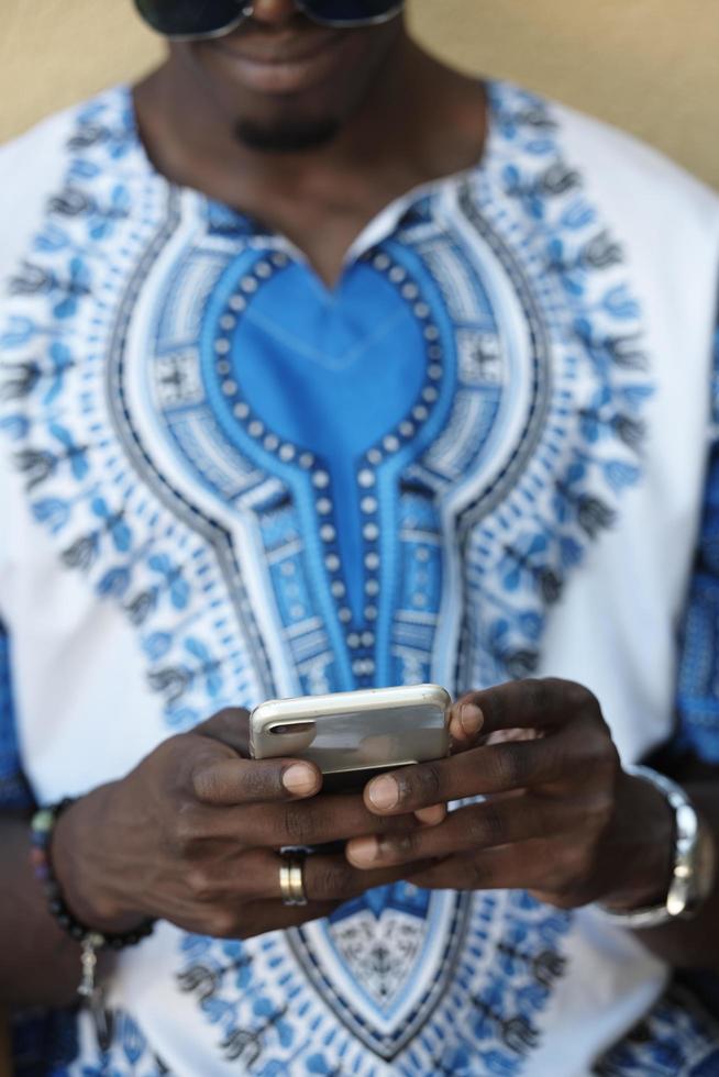 inheems Afrikaanse zwart Mens gebruik makend van slim telefoon foto