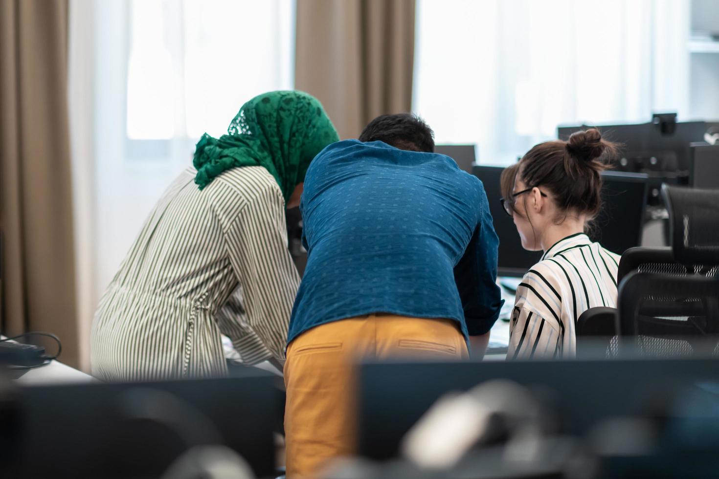 multi-etnisch opstarten bedrijf team Arabisch vrouw vervelend een hijab Aan vergadering in modern Open plan kantoor interieur brainstormen, werken Aan laptop en bureaublad computer. selectief focus foto