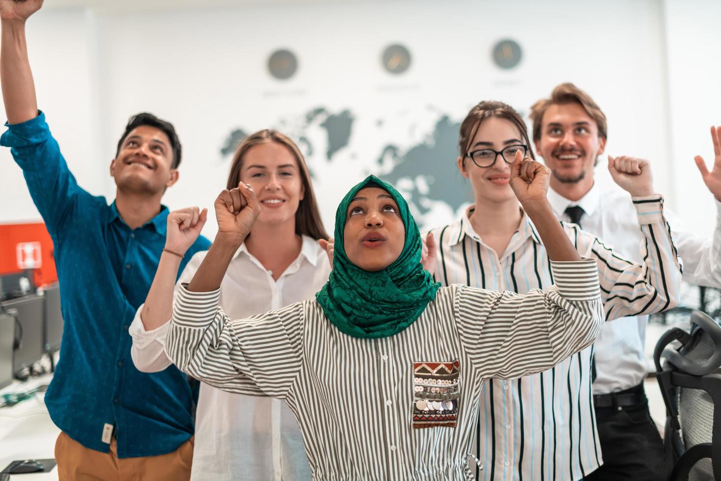 portret van jong opgewonden multi-etnisch bedrijf team van software ontwikkelaars staand en op zoek Bij camera Bij modern opstarten kantoor foto