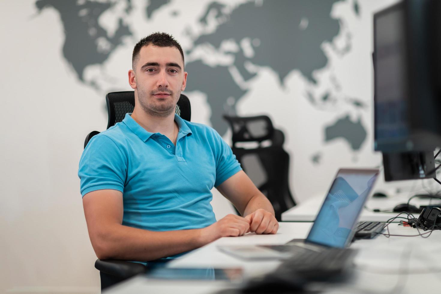 jong Mens zittend in kantoor en werken Aan bureaublad pc. zakenman op zoek Bij computer toezicht houden op terwijl werken in kantoor. foto