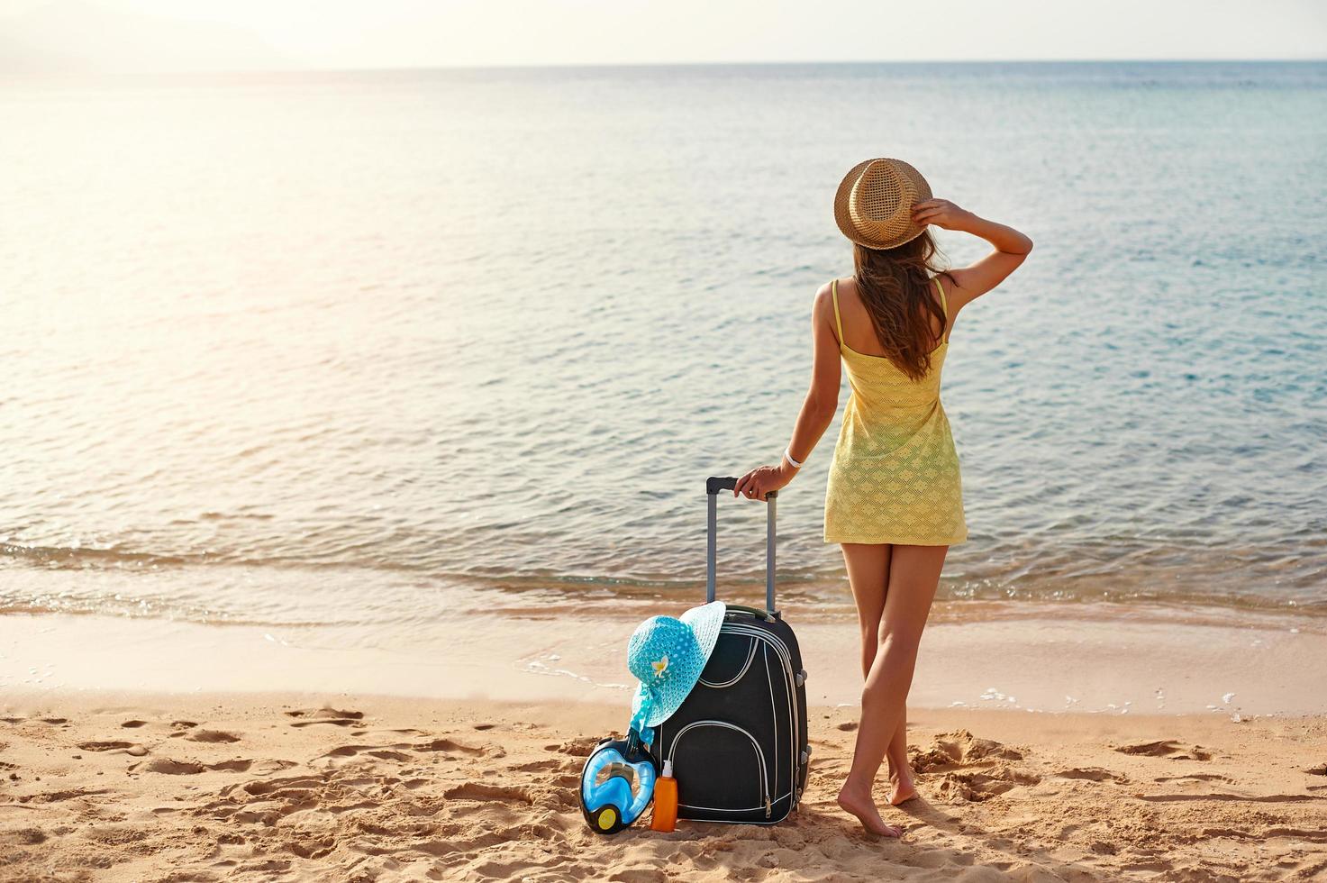 mooie jonge vrouw met een hoed op het strand foto