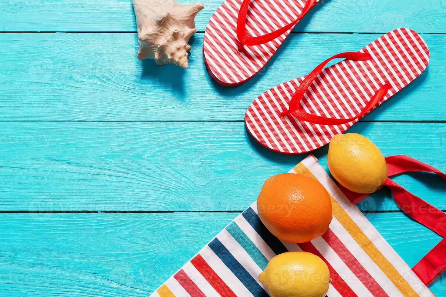 omdraaien flops Aan blauw houten achtergrond. zomer accessoires. vruchten. kopiëren ruimte. bespotten omhoog. zee schelp foto