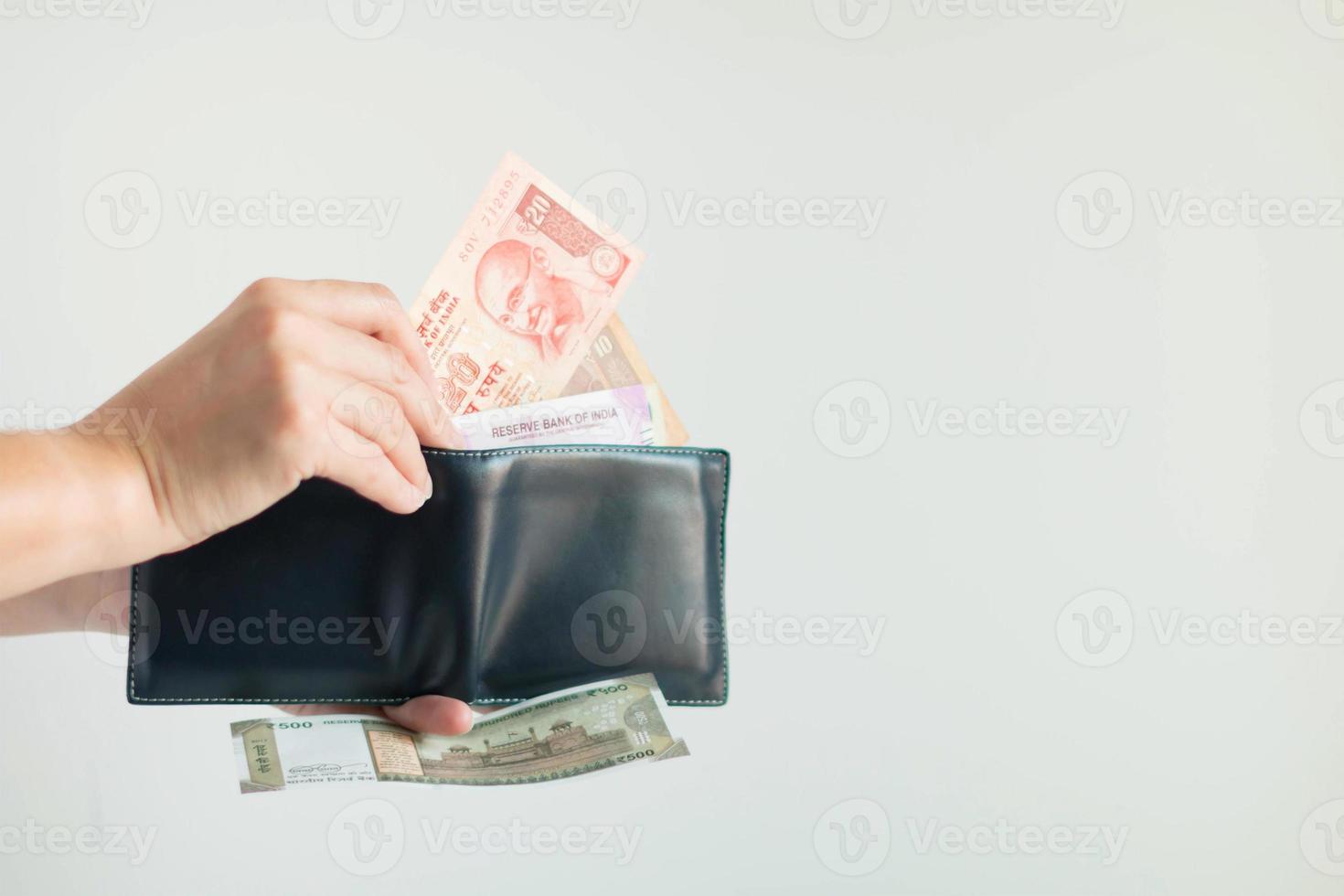 handen plukken roepies geld van de kort portemonnee voor betaling in de republiek van Indië. foto