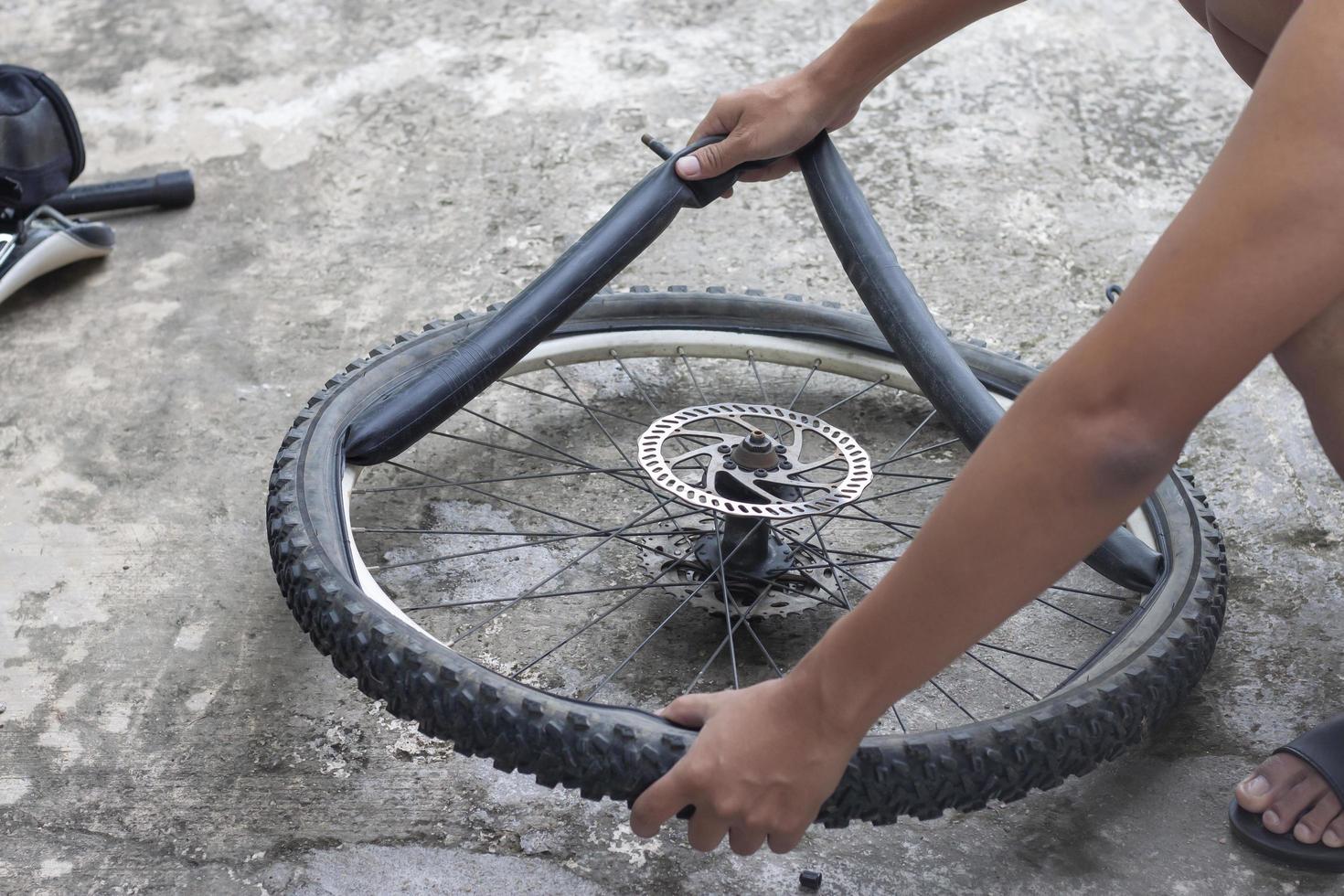 de hand- van een monteur is veranderen de banden van de fiets. foto