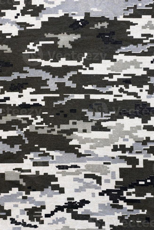 kleding stof met structuur van oekraïens leger korrelig camouflage. kleding met camo patroon in grijs, bruin en groen pixel vormen. officieel uniform van oekraïens soldaten foto