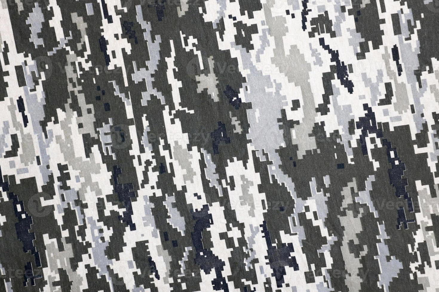 kleding stof met structuur van oekraïens leger korrelig camouflage. kleding met camo patroon in grijs, bruin en groen pixel vormen. officieel uniform van oekraïens soldaten foto