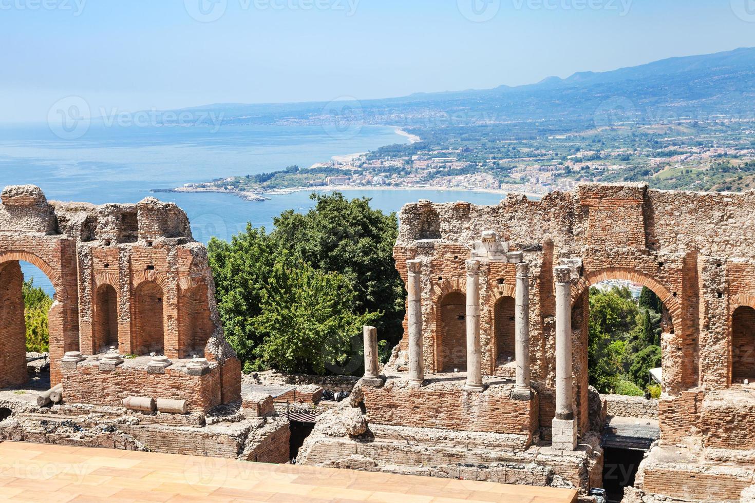 visie van geruïneerd teatro greco en Ionische zee kust foto