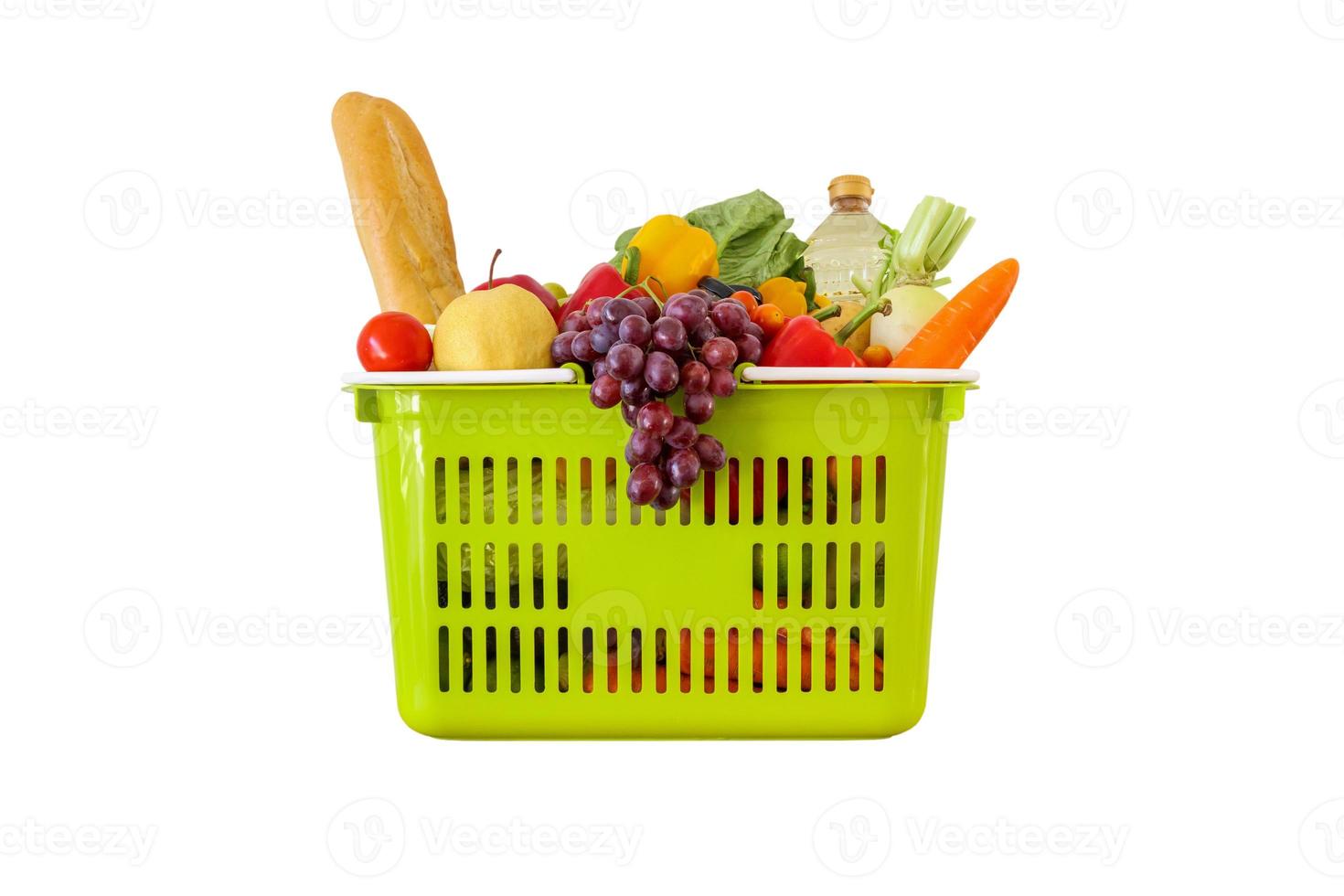 verse groenten en fruit kruidenier product in groene winkelmandje geïsoleerd op een witte achtergrond foto