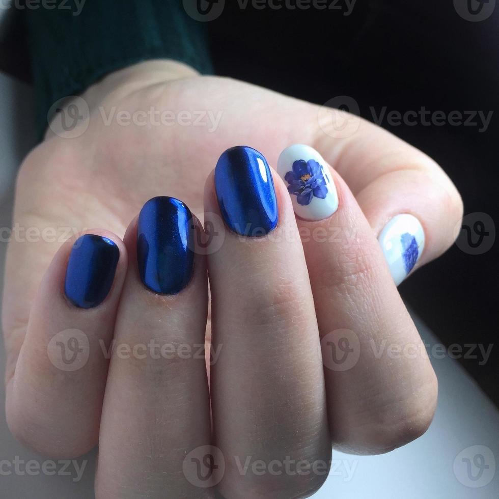 blauw vrouw manicure Aan nagels dichtbij omhoog foto