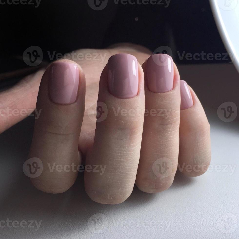 elegant modieus vrouw roze manicure.handen van een vrouw met roze manicure Aan nagels foto