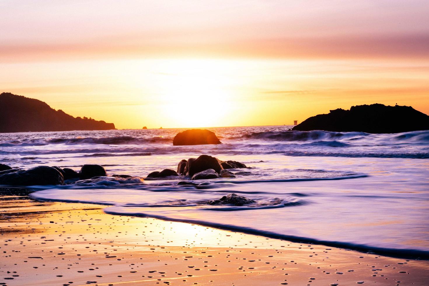 zonsondergang over de horizon op een strand foto
