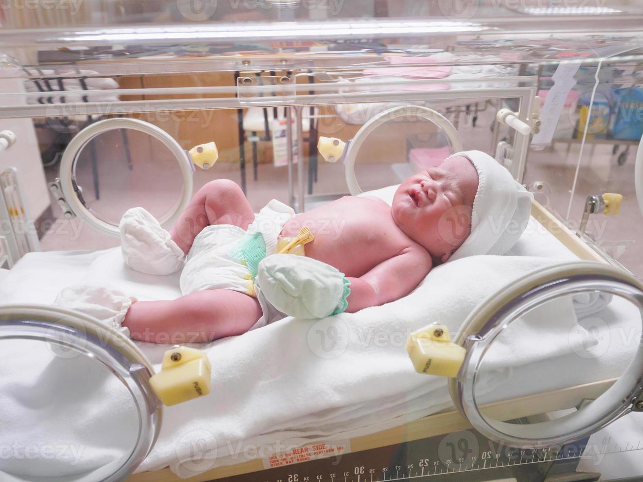 nieuw geboren baby zuigeling slaap in de incubator Bij ziekenhuis foto