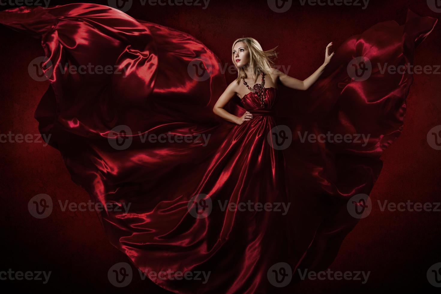 vrouw in rode jurk dansen met vliegende stof foto