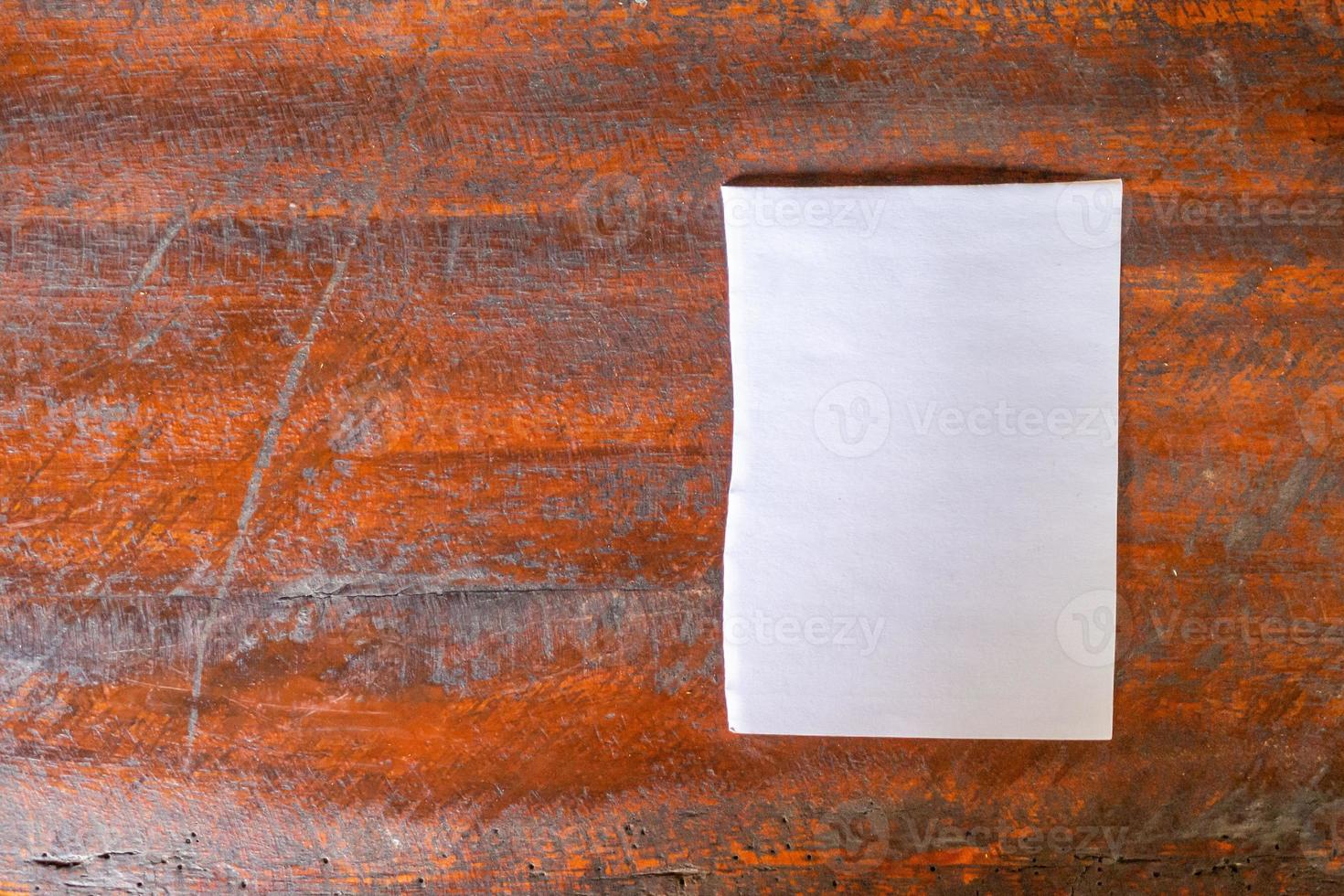 blanco wit papier Aan oud rustiek hout tafel achtergrond foto
