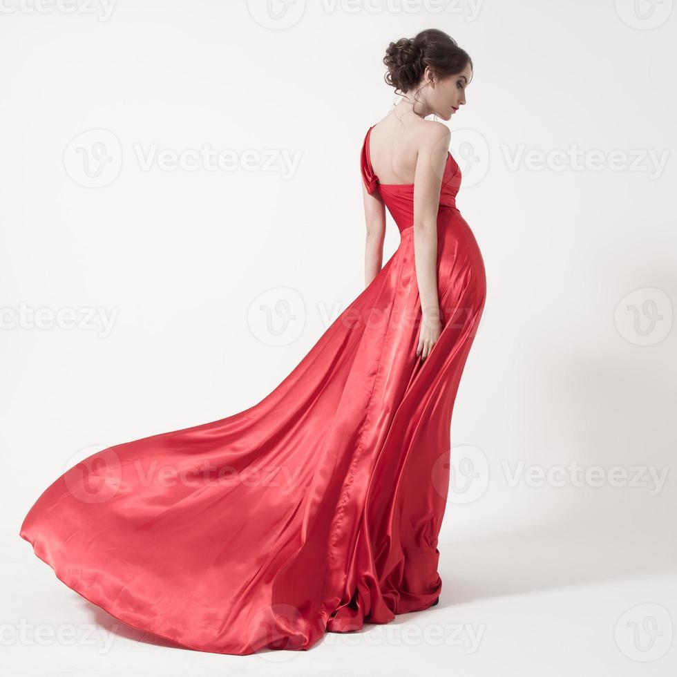 jonge schoonheid vrouw in fladderende rode jurk. witte achtergrond. foto